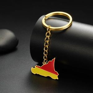 Detailed close-up of golden Sicily map keychain with red and yellow enamel on black background