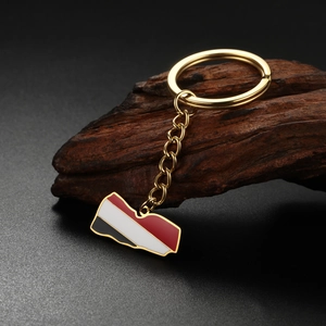 Detail of Yemen flag map keychain with gold finish on rustic wood background