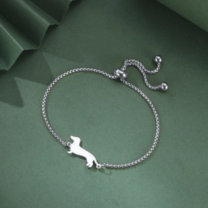 Detail of silver dachshund dog pendant on a stainless steel square chain bracelet