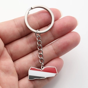 Detailed close-up of Yemen map keychain with flag colors held in a person's palm