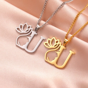 Détail du pendentif lettre U avec visage de femme et lotus en finitions or et argent