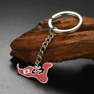 Détail d'un porte-clés avec pendentif en émail carte des Tonga rouge sur un bloc de bois