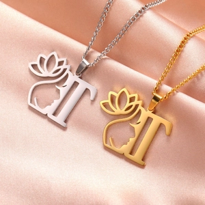 Vue détaillée de colliers alphabet T bicolores or et argent avec lotus sur soie