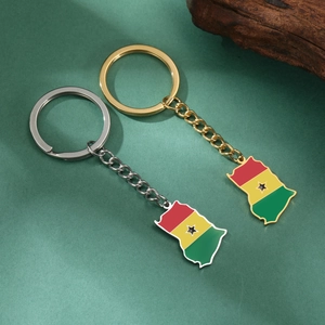 Close-up of gold and silver Ghana map keychains with colorful flag enamel detailing