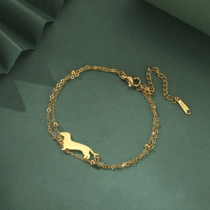 Detail of golden stainless steel double-layer bracelet with dachshund pendant and beads