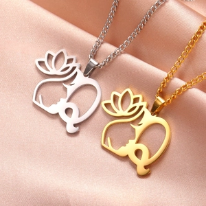 Détail de pendentifs lotus et visage en or et argent sur tissu en soie brillant