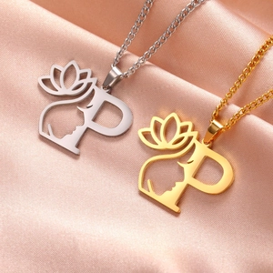 Détails des colliers pendentifs lotus et alphabet or et argent sur tissu en soie
