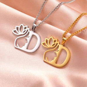 Macro détaillée de colliers D en or et argent avec motif lotus et profil de visage féminin