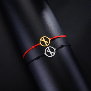 Detail von gewebten Seilarmbändern mit silbernen und goldenen Runen-Metallanhängern