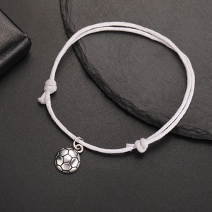 Detail of adjustable white braided rope bracelet with vintage silver soccer ball charm