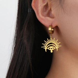 Golden Horus Eye stainless steel drop earrings with sunburst pendant on a female model