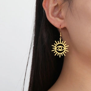 Golden Sunburst Evil Eye drop earrings in stainless steel on a model with white background