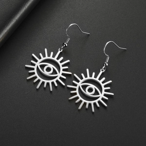 Detalle macro de pendientes de acero inoxidable con diseño de ojo turco sobre cuero negro