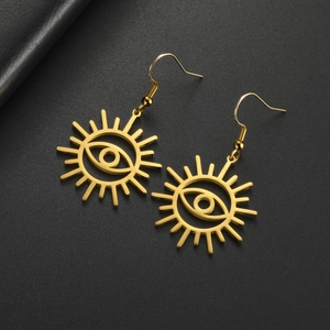 Detalle de pendientes dorados de ojo turco con rayos solares sobre cuero negro