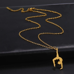 Close-up of golden stainless steel necklace with rhythmic gymnast pendant on black leather