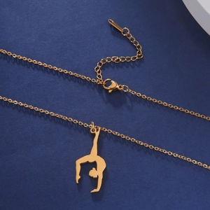 Close-up of golden rhythmic gymnast silhouette pendant on textured navy background