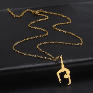 Detailed view of rhythmic gymnast pendant necklace in golden finish on black background