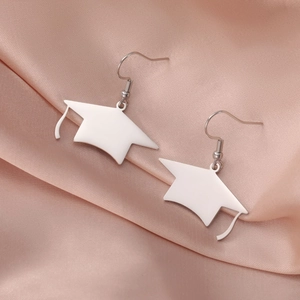 Boucles d'oreilles chapeau diplômé en acier argenté sur fond de soie rose