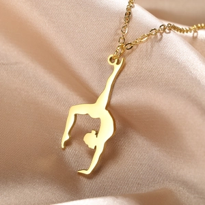 Macro shot of gold rhythmic gymnast silhouette pendant on champagne silk fabric background