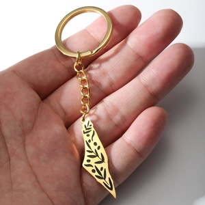 Gold Israel map keychain with olive branch engraving held in hand to show size
