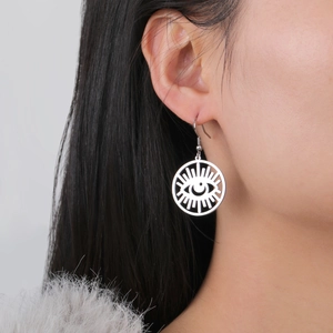 Silver stainless steel evil eye drop earrings with celestial sunburst design on model