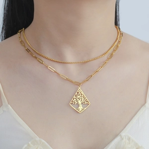 Detail of double-layer gold necklace featuring a diamond-shaped Tree of Life pendant