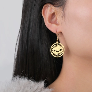 Elegant gold evil eye crescent moon drop earrings worn by a model in close-up view