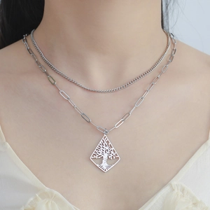 Detail of double-layer stainless steel necklace with hollow tree of life diamond pendant