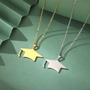 Detail view of gold and silver graduation cap pendants on green pleated backdrop
