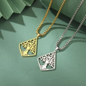 Detail showing two hollow tree of life pendants in gold and silver on an olive background