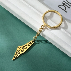 Macro detail of gold Israel map keychain with black floral patterns and polished finish