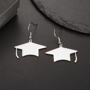 Vue détaillée de boucles d'oreilles chapeau de diplômé en argent sur fond noir