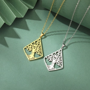 Detailed macro view of gold and silver hollow tree of life pendants on dark green background