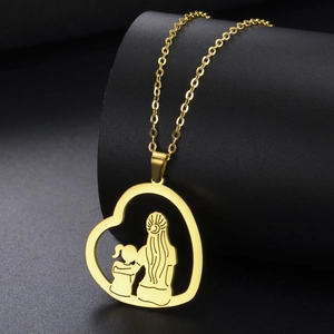 Makroaufnahme der goldenen Herz-Halskette mit einer Silhouette von Mutter und Kind