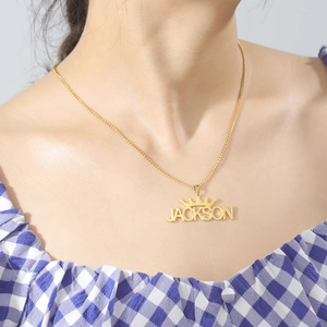 Detailed view of custom gold crown name necklace Jackson on model's neckline