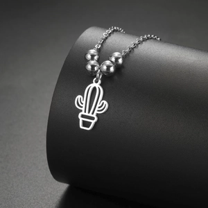 Detail shot of a silver hollow cactus pendant with metal beads on a stainless steel necklace