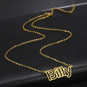 Detailaufnahme der personalisierten Namenskette Billy in Gold auf schwarzem Lederhintergrund