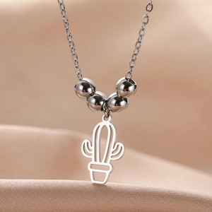 Detailed close-up of hollow cactus pendant with polished metal beads on silver necklace