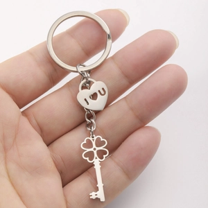 Silver stainless steel heart and clover key pendant keychain held by hand
