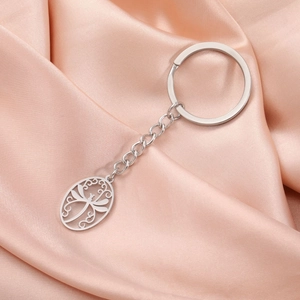 Elegant stainless steel oval dragonfly keychain with filigree details on satin