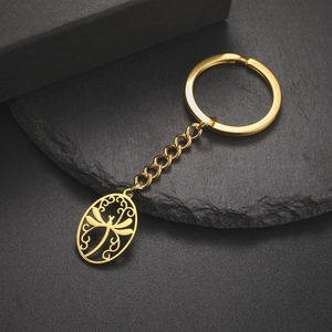 Detailed close-up of golden stainless steel dragonfly keychain with intricate hollow design