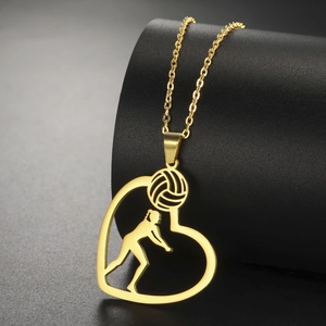 Detalle de un collar de voleibol de corazón dorado con silueta en un soporte negro