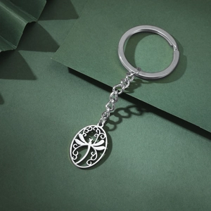 Detail of oval dragonfly pendant on stainless steel keychain with intricate vine patterns