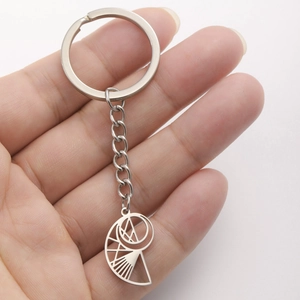 Titanium steel keychain with geometric hollow nautilus pendant held in hand over white background