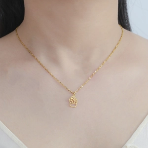 Close-up of golden stainless steel necklace with hollow cactus pendant on model