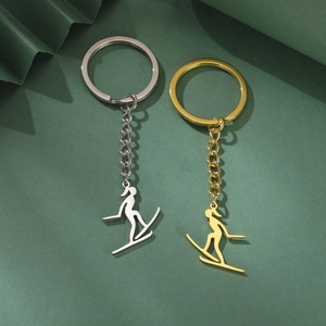 Détails macro des pendentifs skieur en or et argent avec finition en métal poli