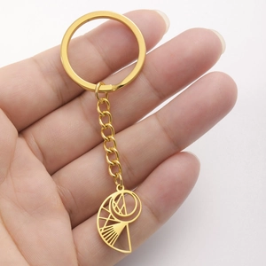 Polished gold stainless steel keychain with hollow conch pendant held by hand