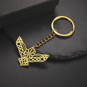 Detailed macro view of golden eagle wing keychain with celtic knot and compass symbol