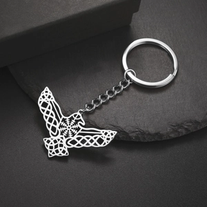 Detailed close-up of Celtic eagle key ring with Viking compass on black stone surface