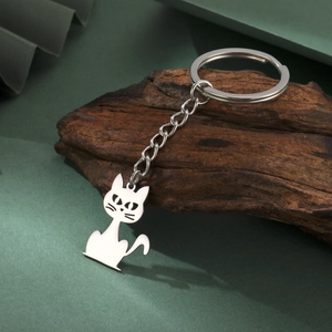 Polished stainless steel cat silhouette keychain on a decorative natural wood branch